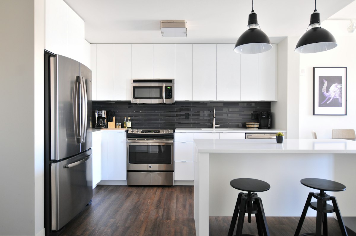 White modular kitchen with dark backsplash